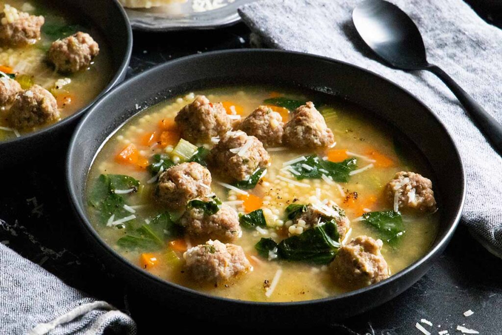 Italian wedding soup in black bowl