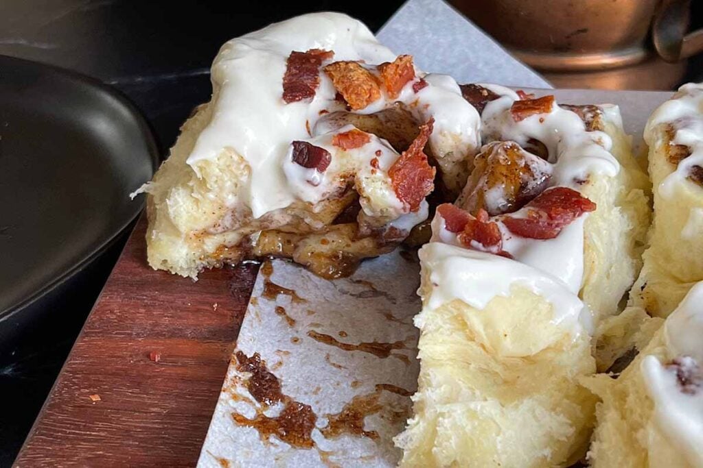 A maple bacon cinnamon roll cut open.