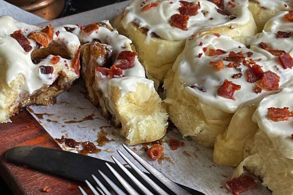 Maple bacon cinnamon roll cut in half.