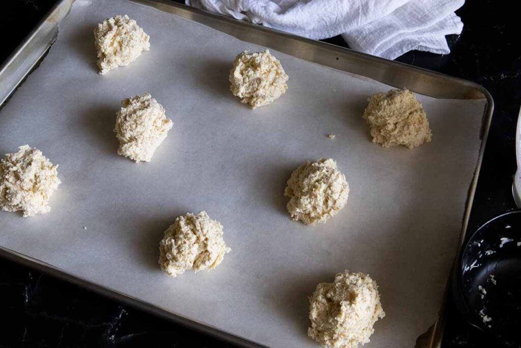 biscuits dropped on parchment lined baking sheet