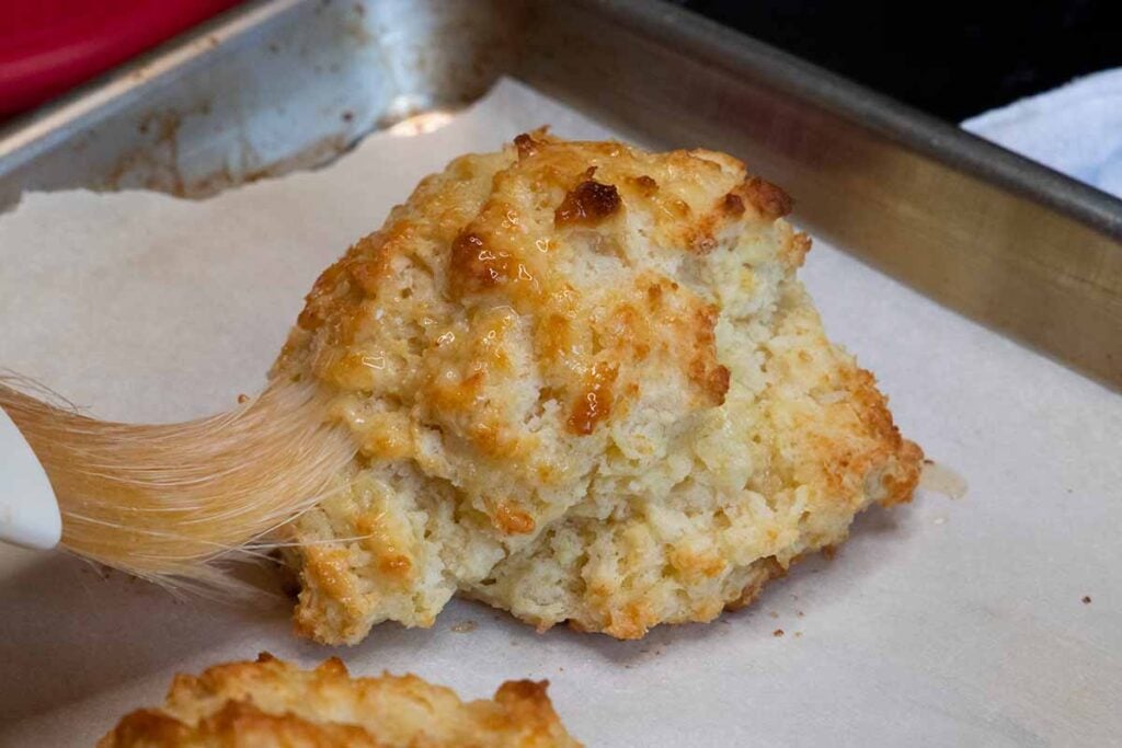 Biscuit being brushed with melted butter.