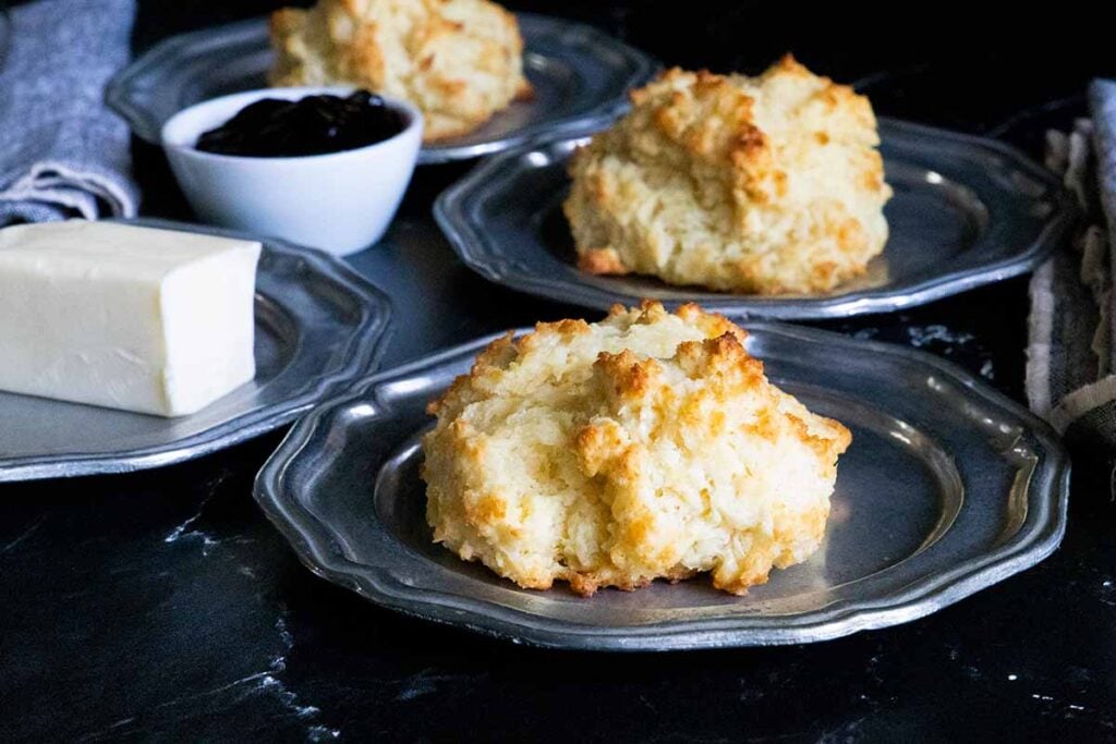 Buttermilk drop biscuits on silver plates.