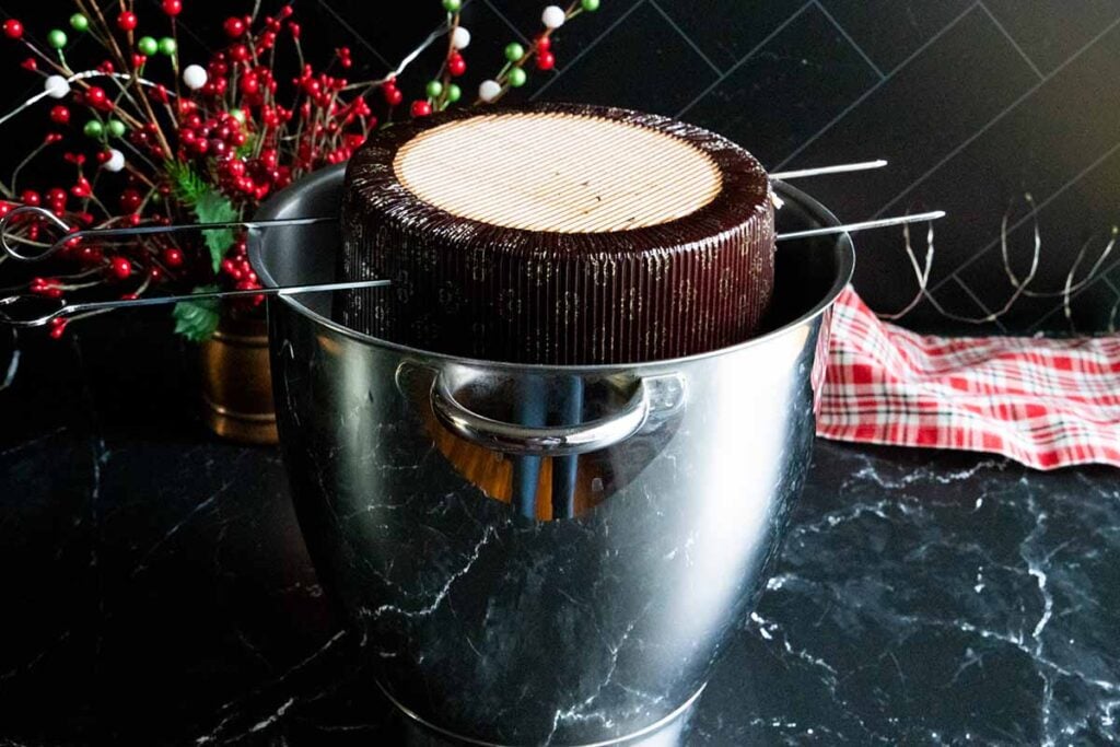 panettone hanging upside down in a mixing bowl