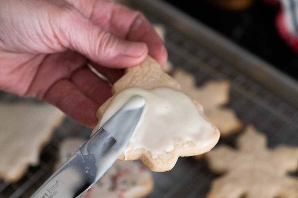 glaze being spread over the baked cookie