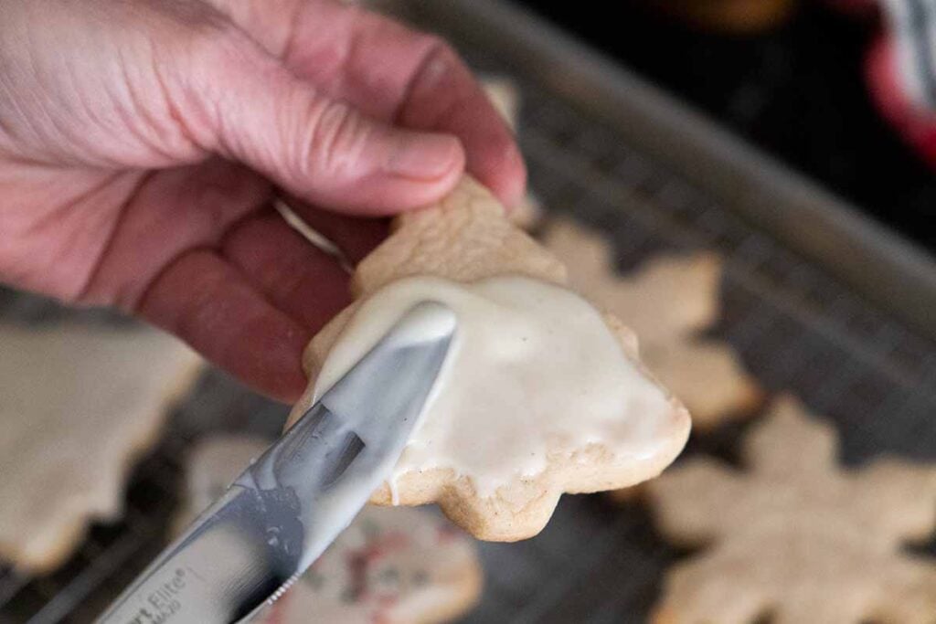 Eggnog glaze being spread over the baked cookie.