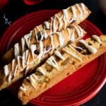 Slices of cranberry pistachio biscotti on a dark plate.