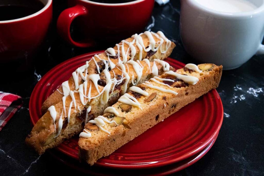 Slices of cranberry pistachio biscotti on a dark plate.