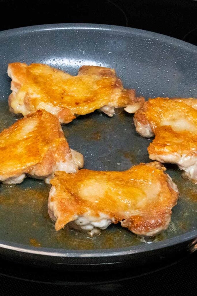 Crispy chicken thighs cooked, in a skillet
