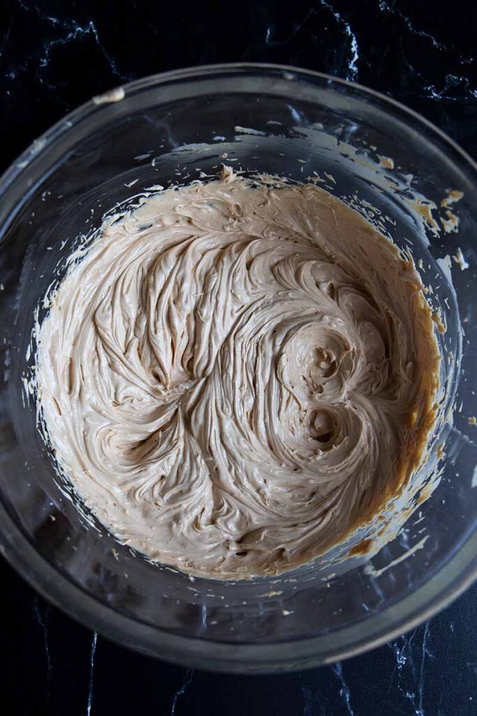 Shortening, butter, and peanut butter creamed together in a glass bowl.