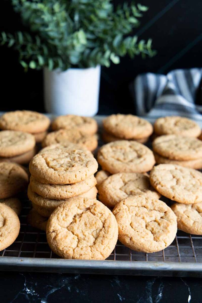 Peanut butter cookies stacked on a wire rack.