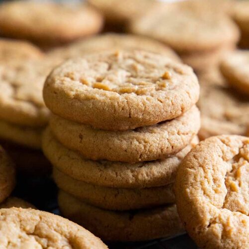 Peanut butter cookies on a wire rack in a baking sheet.