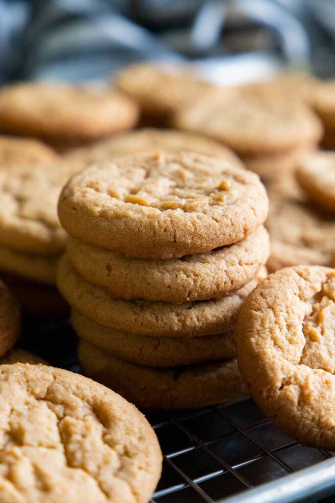 Peanut butter cookies on a wire rack in a baking sheet.