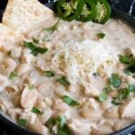 White chicken chili in a black bowl.