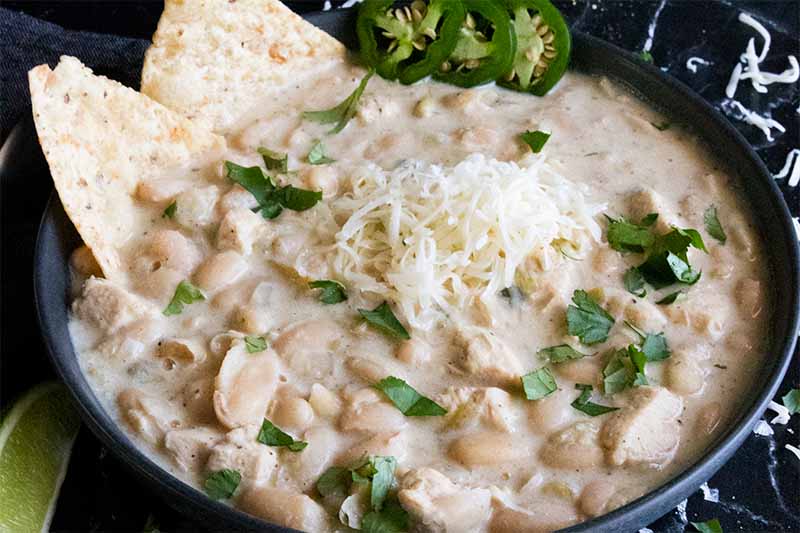 White chicken chili in a black bowl.