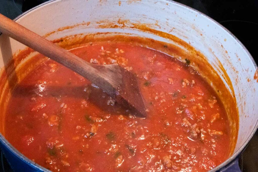 tomato sauce for baked ziti cooking on the stovetop.