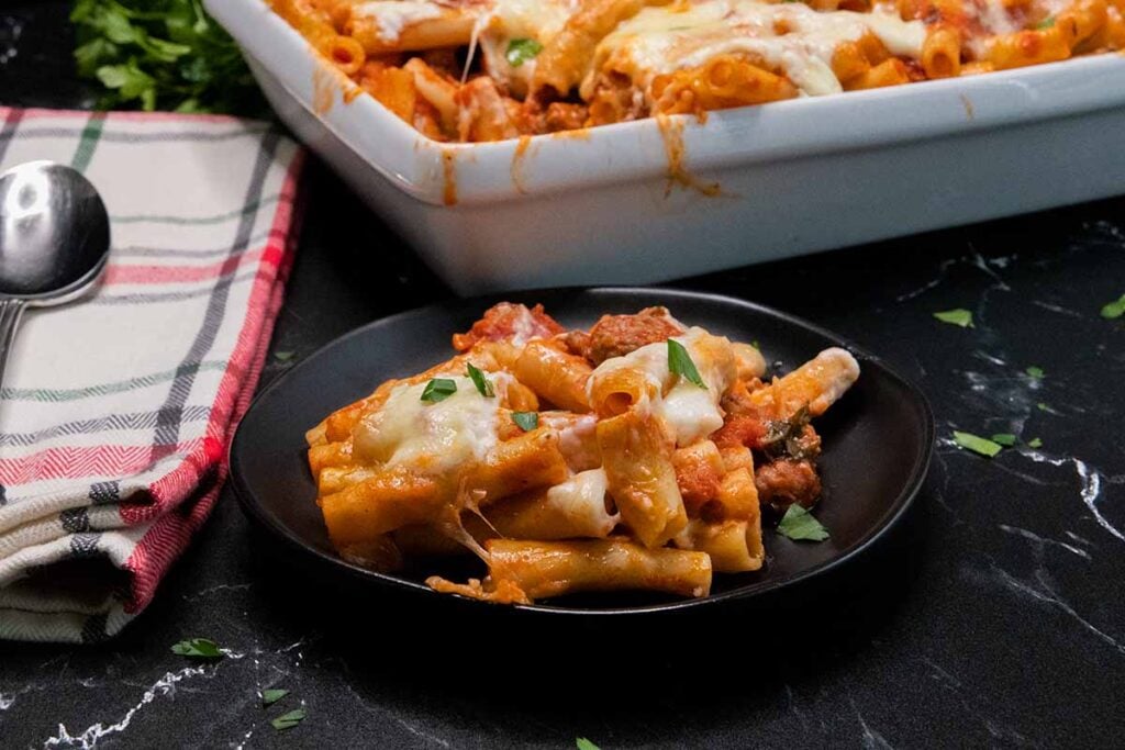 A serving of baked ziti on a dark plate
