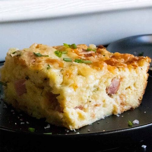 ham and cheese strata slice on black plate