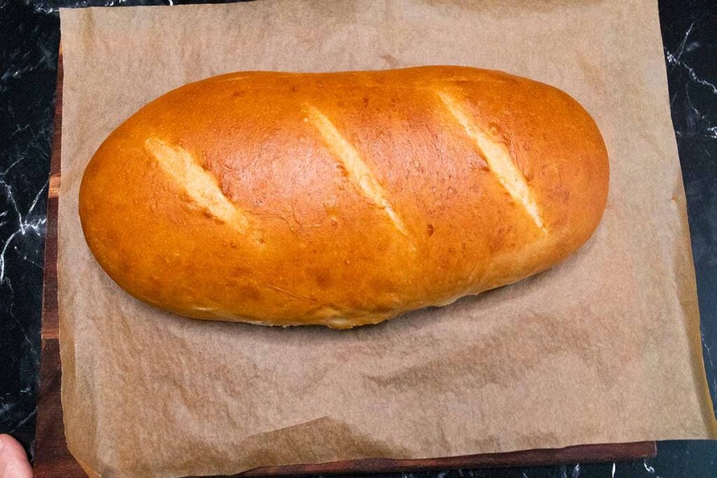 Baked Italian bread on a wooden cutting board.