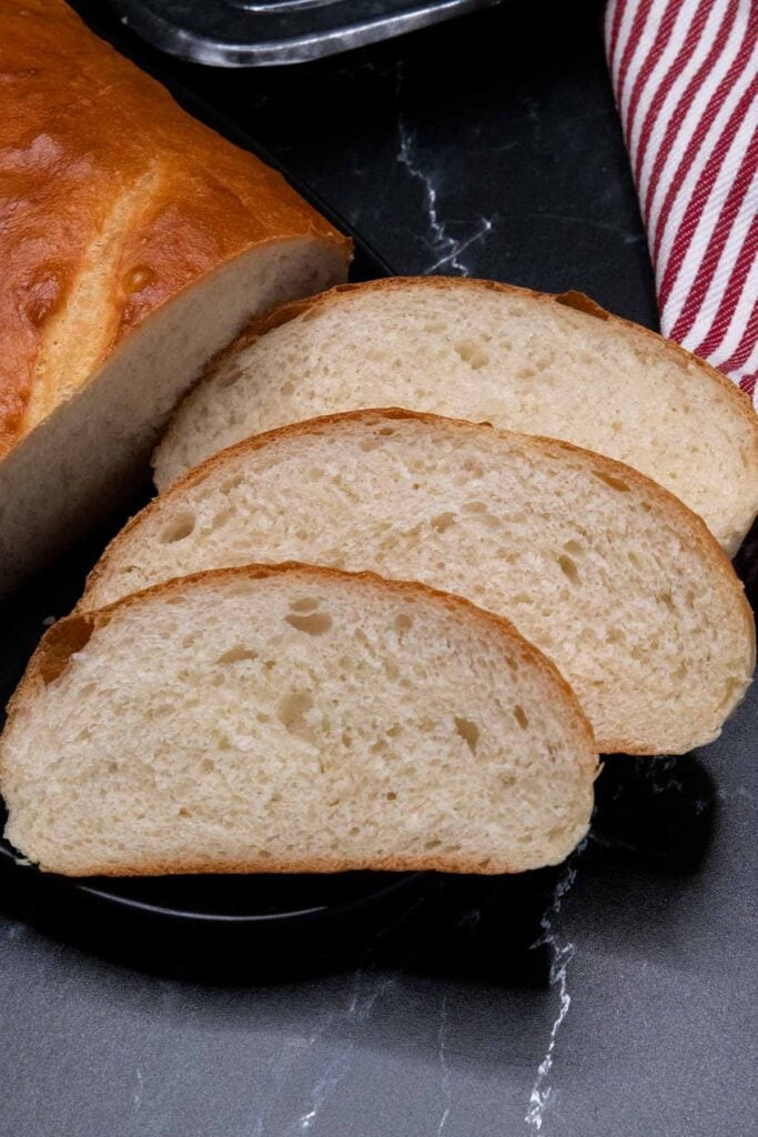 Slices of Italian bread on black platter.