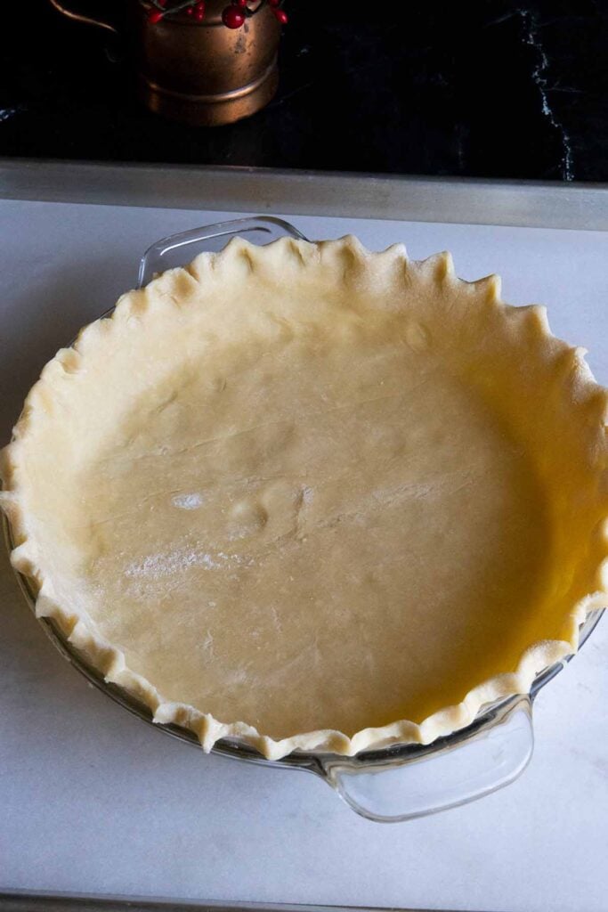 dough pressed in a glass pie plate