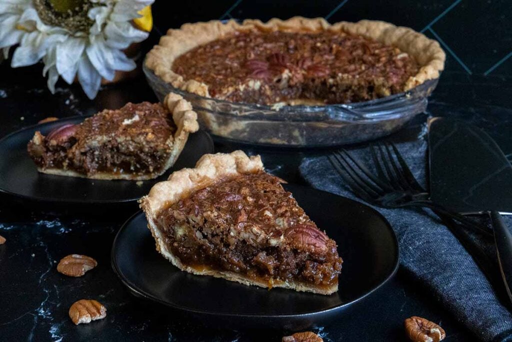 pecan pie slices on black plates