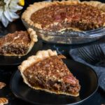 Slices of pecan pie on black plates.