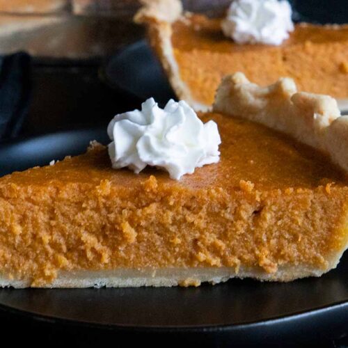 Slices of sweet potato pie on black plates