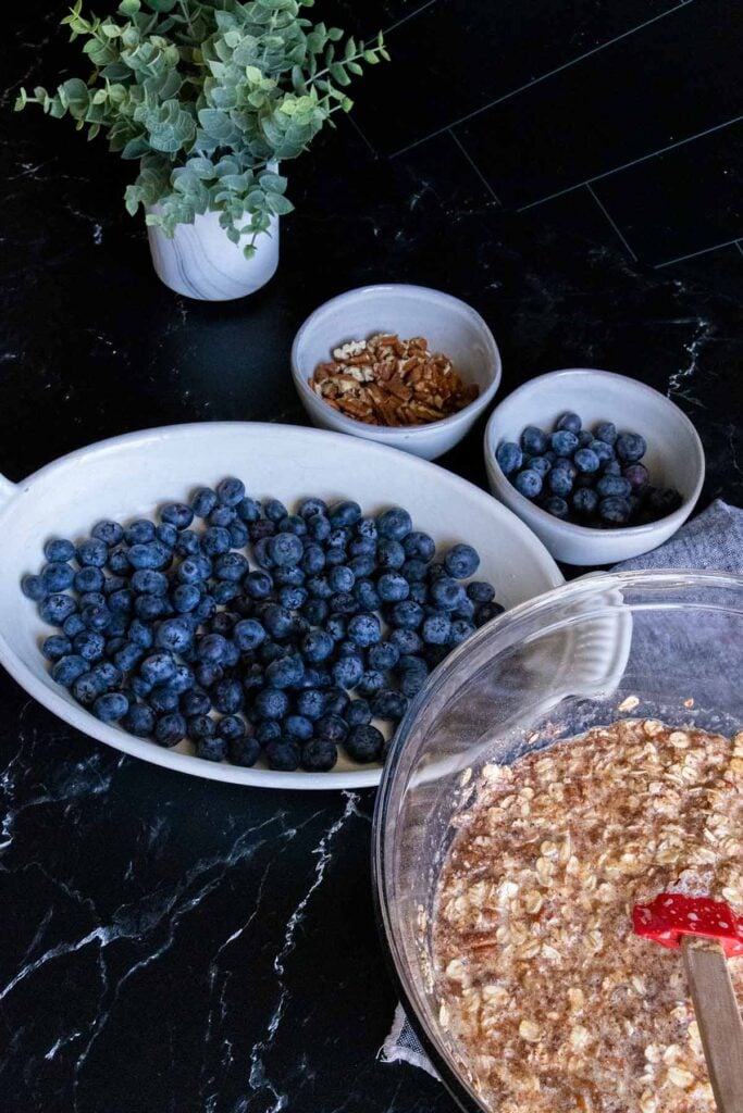 Blueberries scattered in the bottom of a white baking pan.