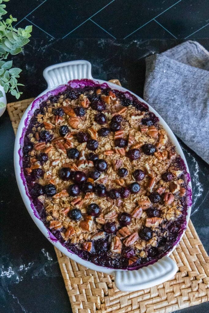 Blueberry baked oatmeal in a white oval baking dish.