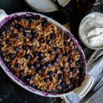 Blueberry baked oatmeal in a white oval baking dish.