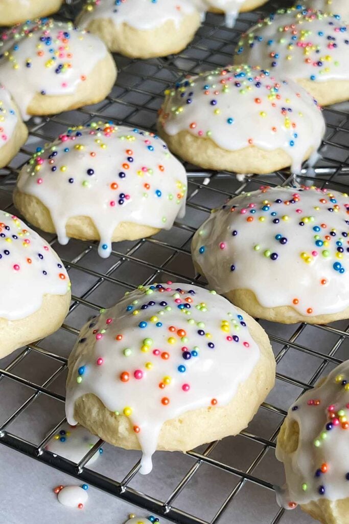 Italian ricotta cookies with glaze drying on a wire rack.