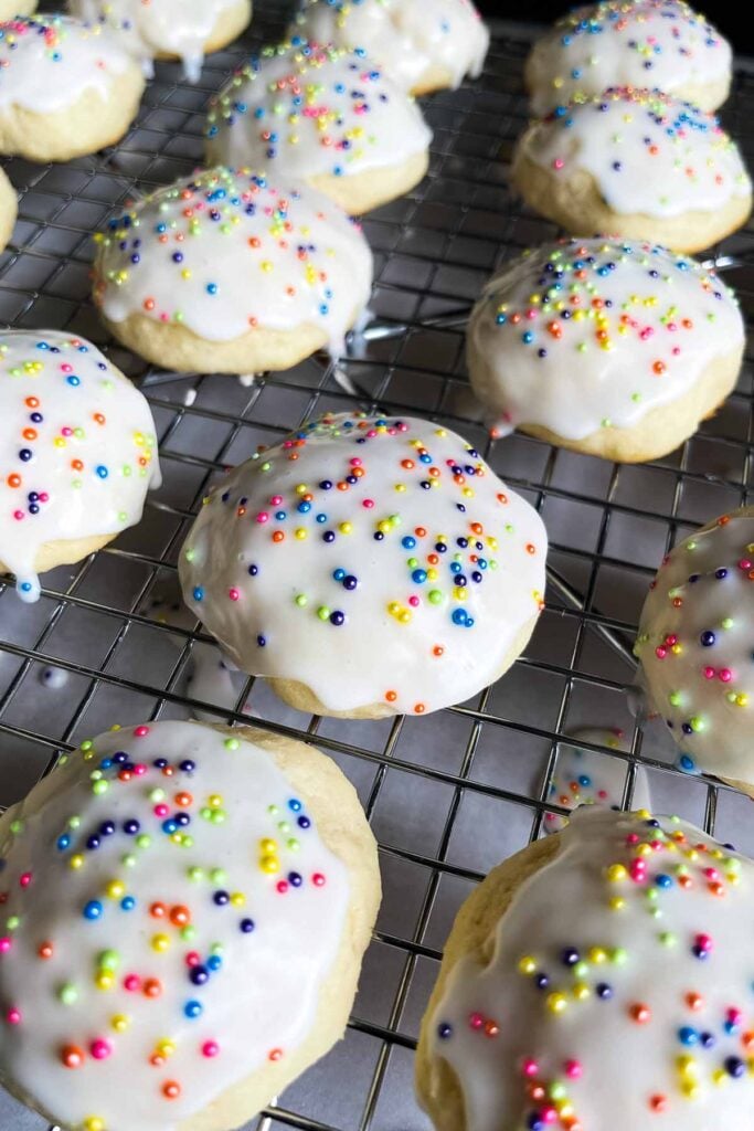 Italian ricotta cookies with glaze drying on a wire rack.