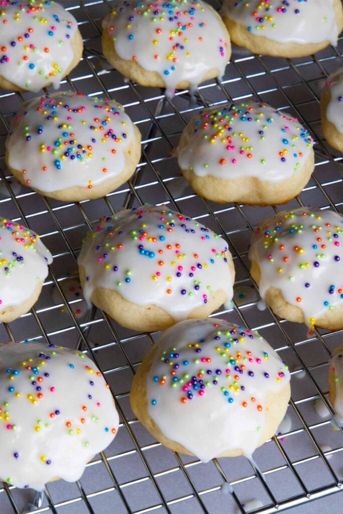 Italian ricotta cookies with glaze drying on a wire rack.