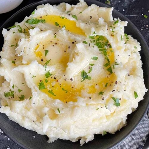 Mashed potatoes with butter in a dark bowl