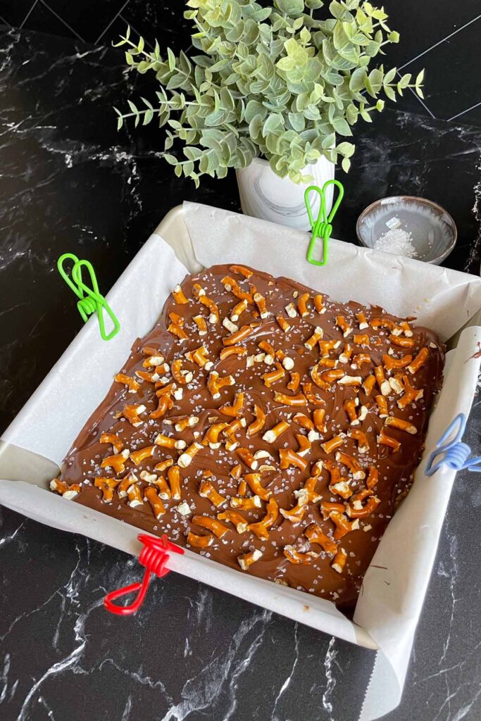 Peanut butter pretzel bars in a lined baking pan.