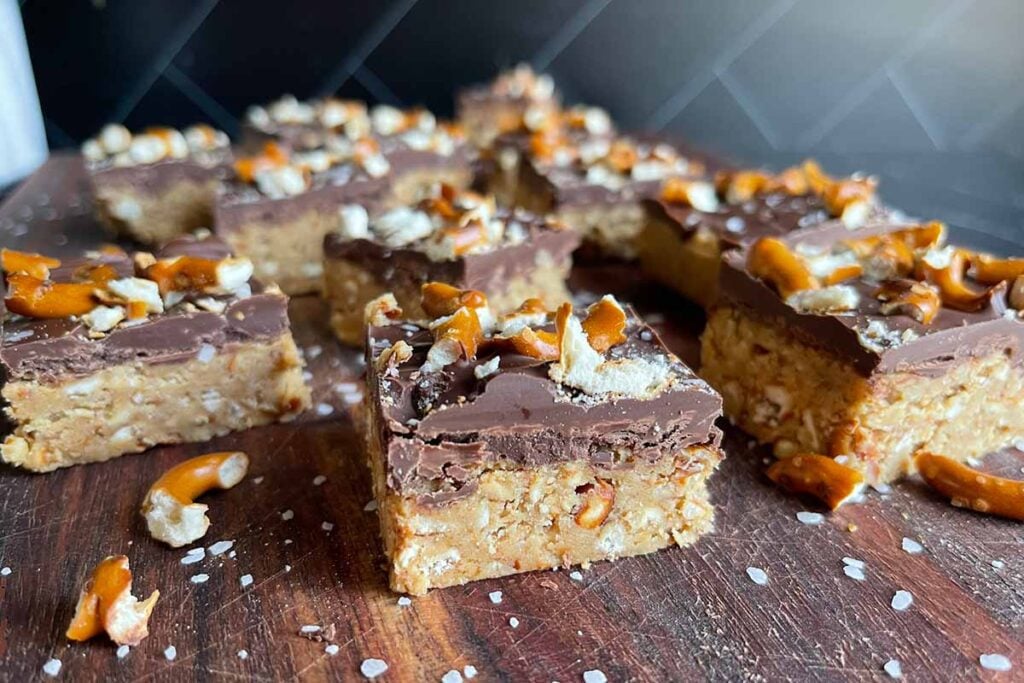 Peanut butter pretzel bars on a dark wooden board.