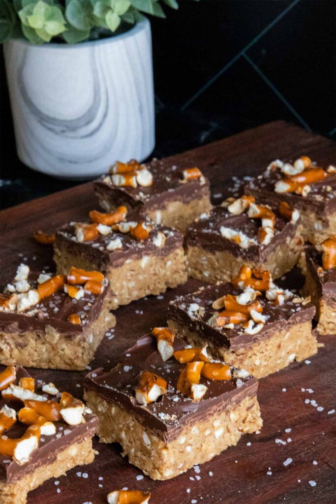 Peanut butter pretzel bars on a wooden cutting board.