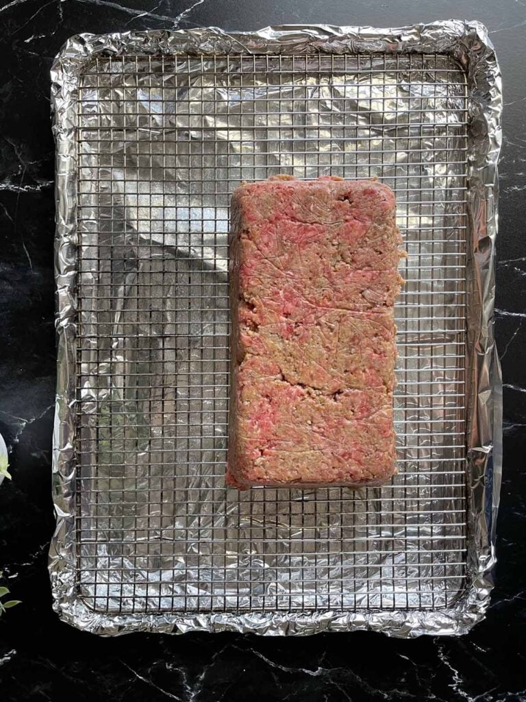 uncooked meatloaf on a bradley rack.