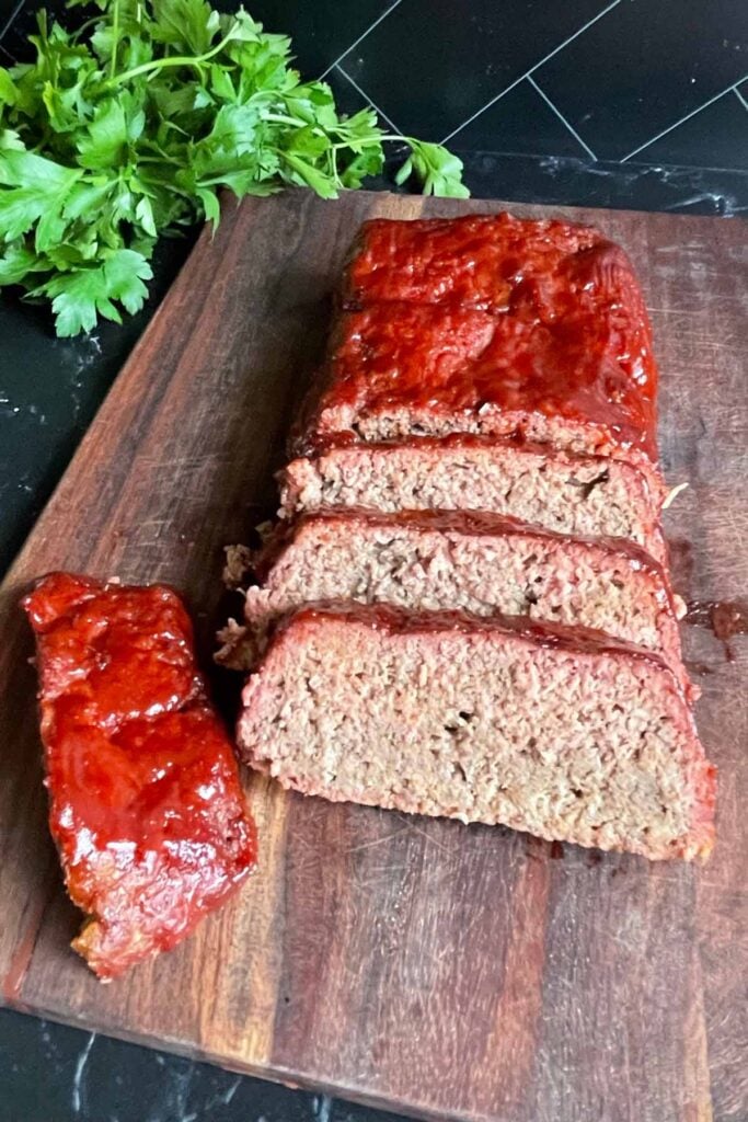 smoked meatloaf sliced on a cutting board.