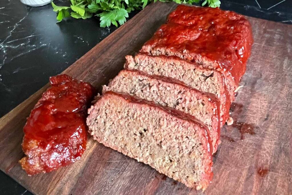 sliced smoked meatloaf on a cutting board.