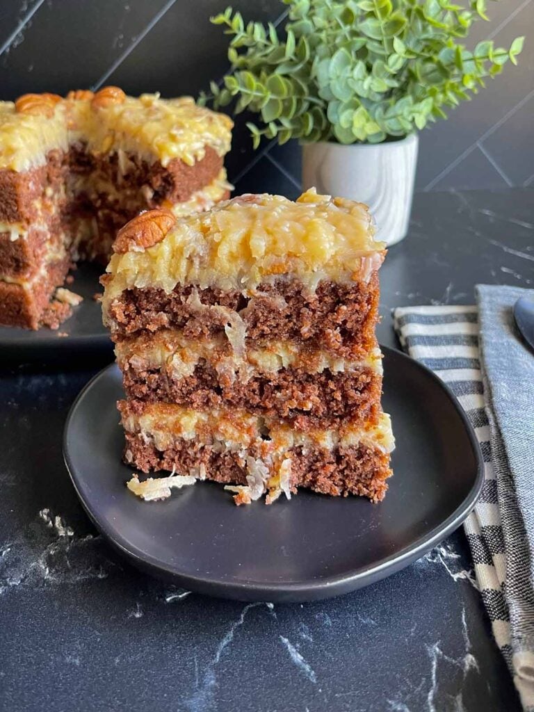 A slice of original Baker's German chocolate cake on a black plate.