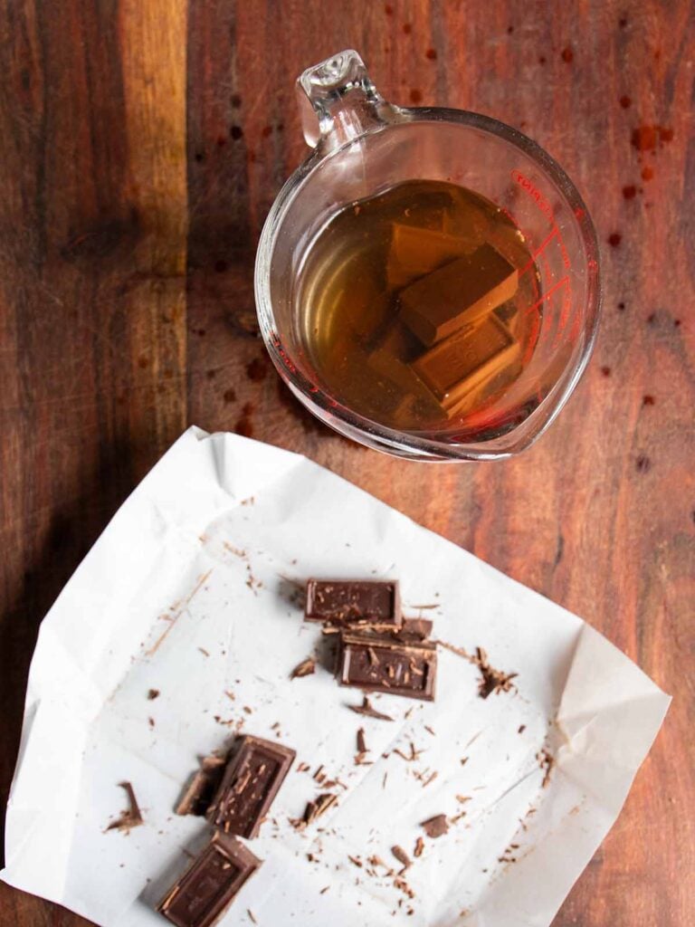 Chocolate squares in a glass measuring cup with boiling water.