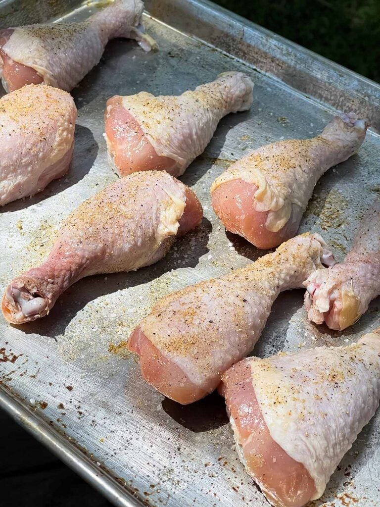 raw chicken legs with a light rub applied.