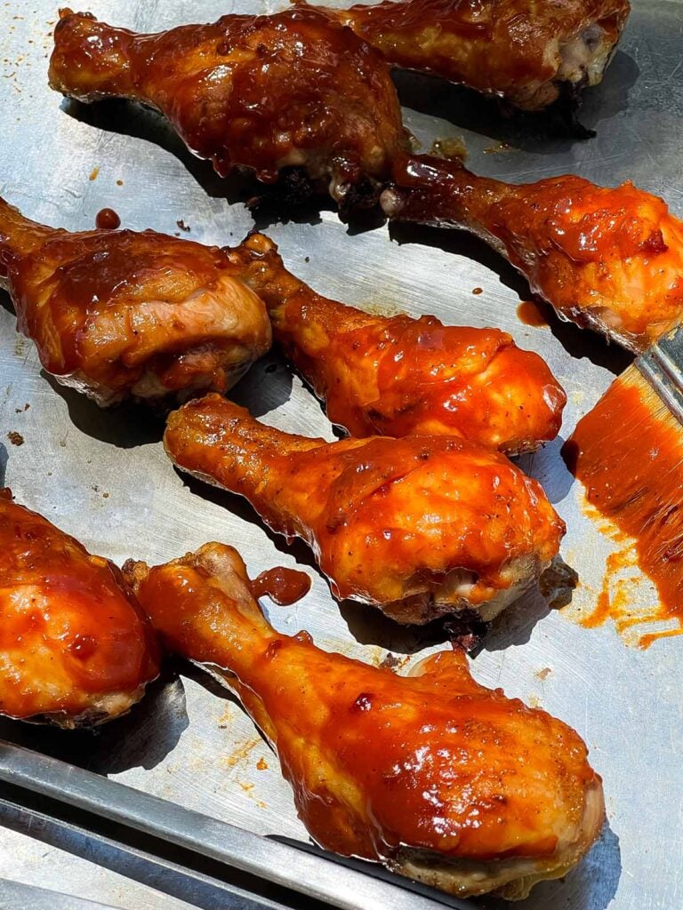 Applying bbq sauce to some grilled chicken.