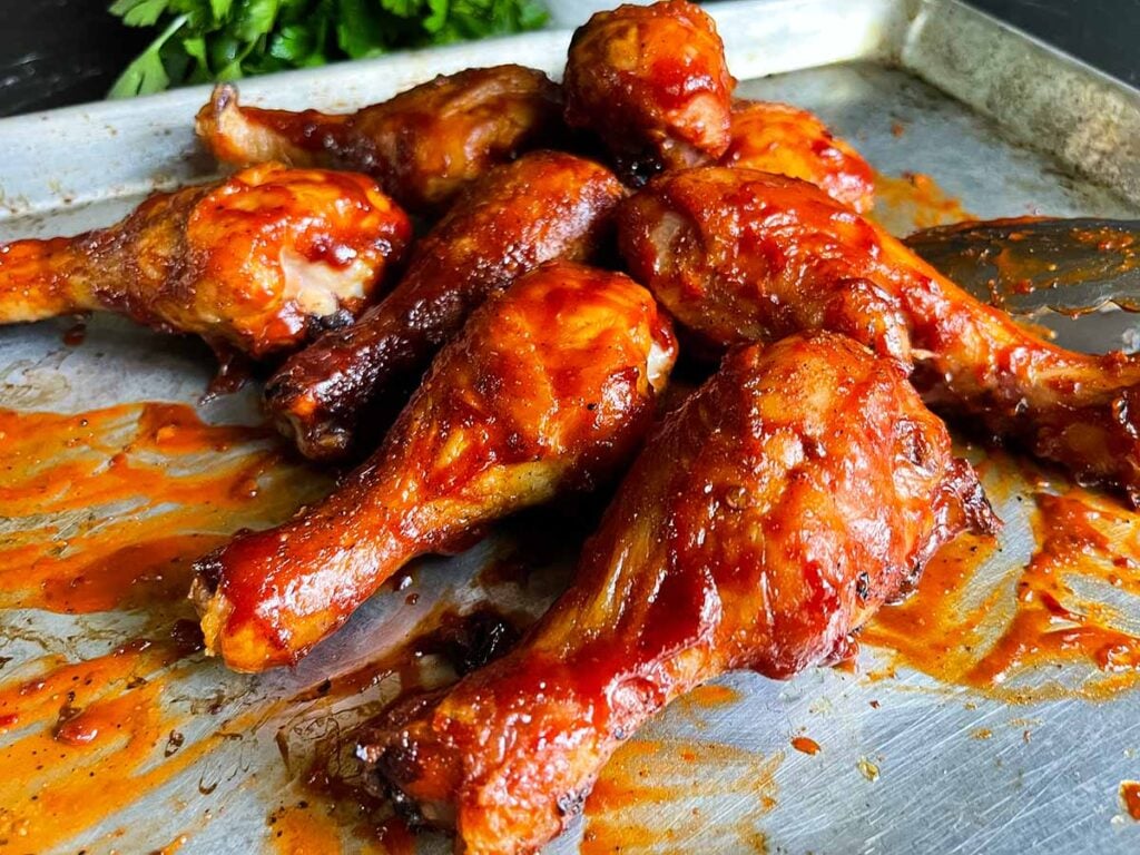 Bbq chicken legs on a baking sheet.