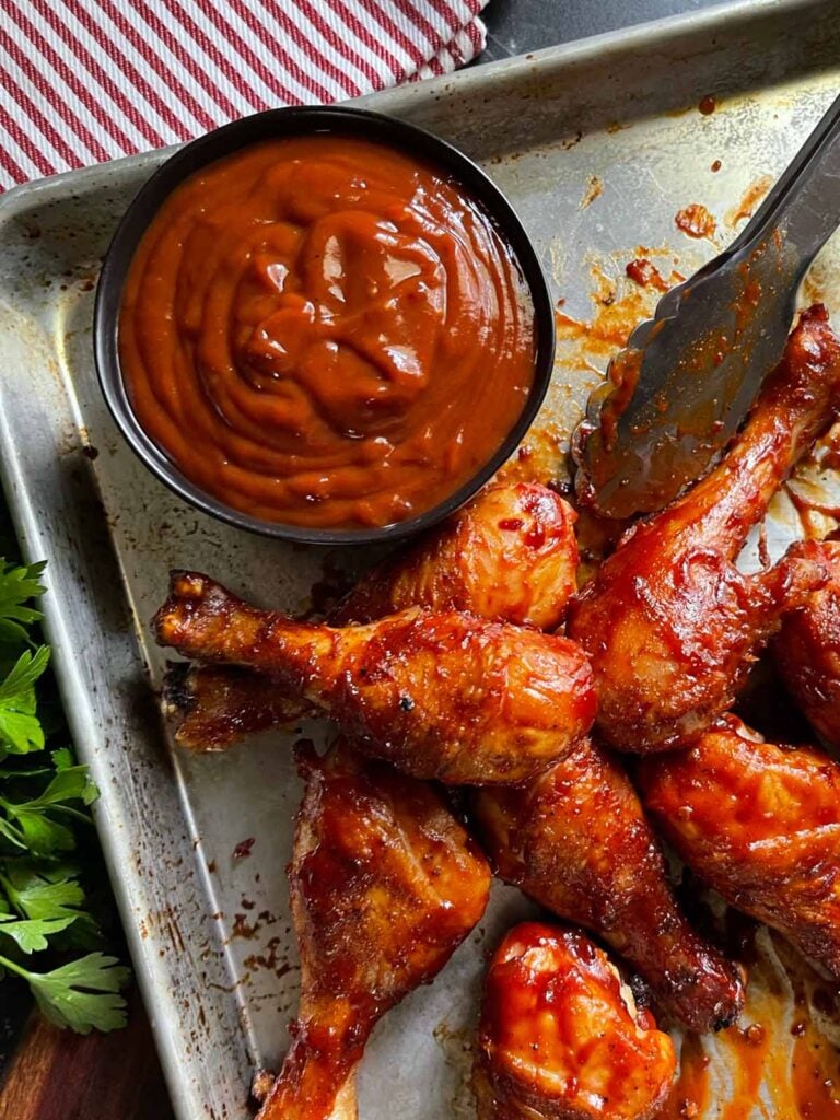 BBQ chicken on a baking dish with homemade bbq suace.