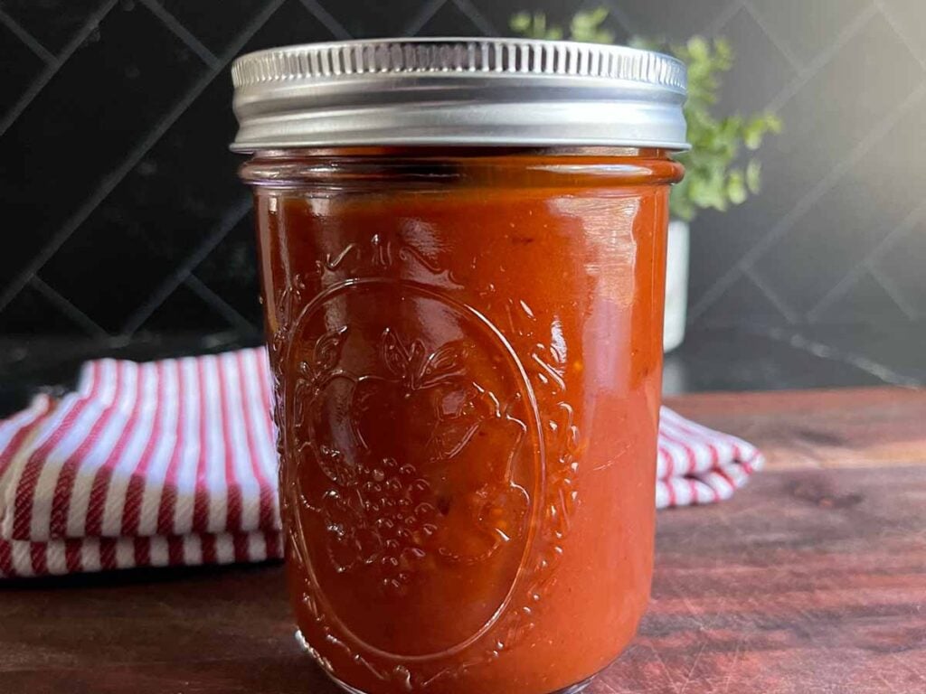 Homemade bourbon chipotle barbeque sauce in a mason jar.