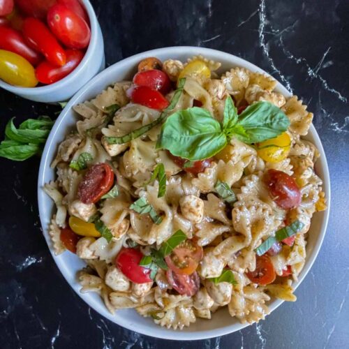 Pesto Caprese Pasta Salad in a white bowl
