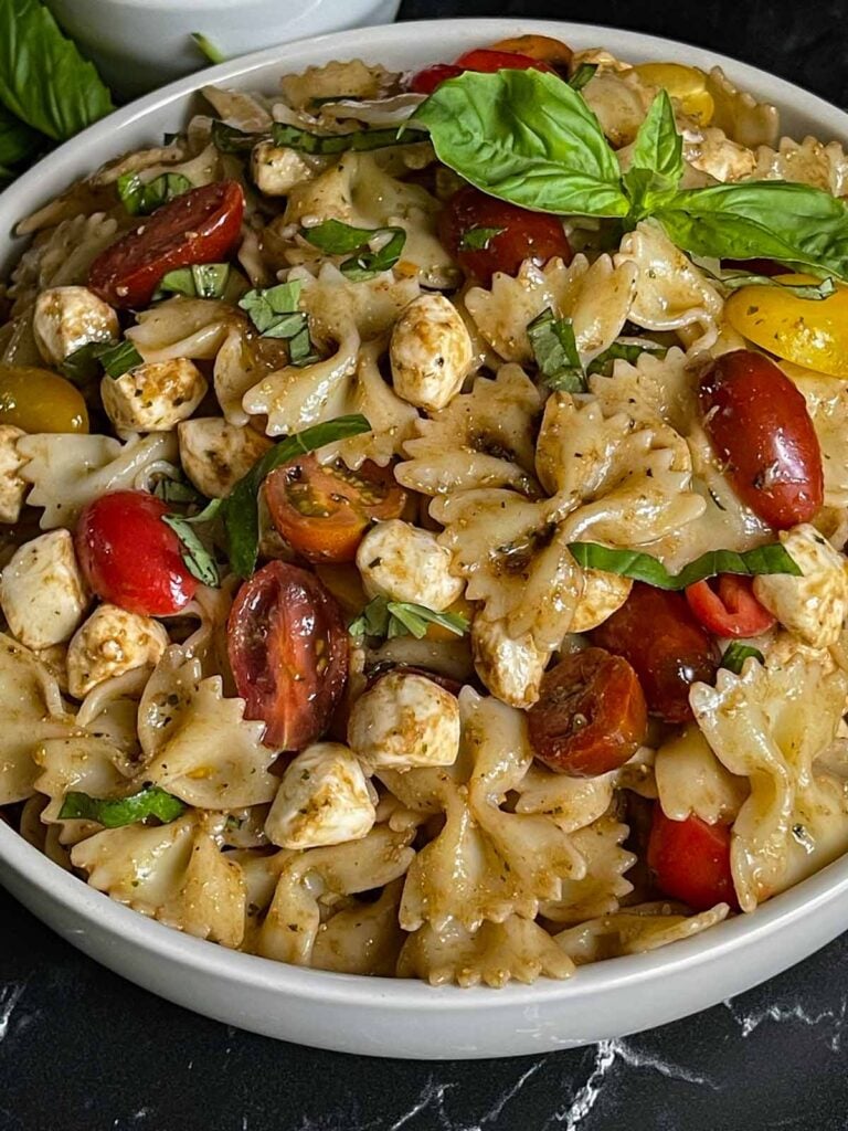 Caprese pasta salad in a white bowl.