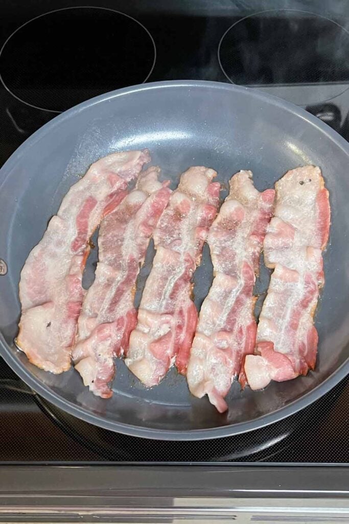 Bacon cooking in a pan.